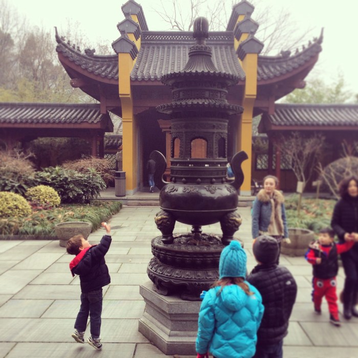 Luke trying to throw a coin into the offering tower for good luck. 