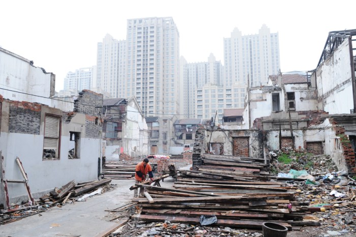 A worker creates a pile of recycled wood.