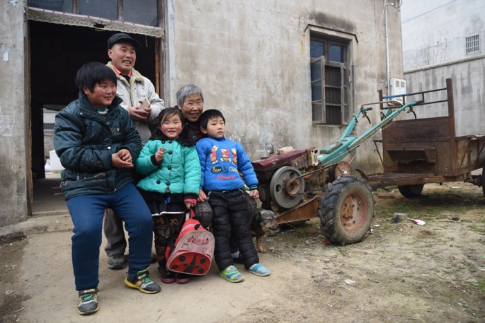 Post operative heart patient, Dong mengxuan, along with her brother, parents, and grandmother. In front of their one-room home. 