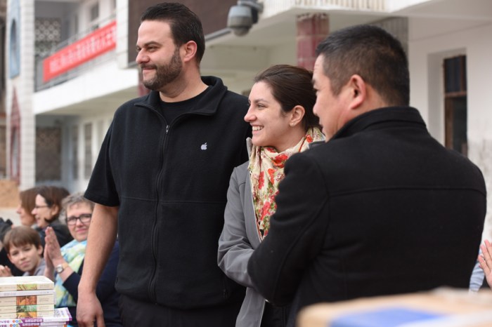 Proud sponsors handing over their donation to the head of school. 